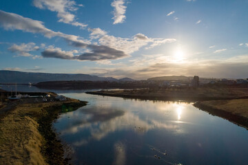 Scenic view of calm river flowing along small coastal settlement