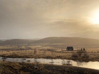 Fototapeta premium Lonesome house located in grassy hilly countryside