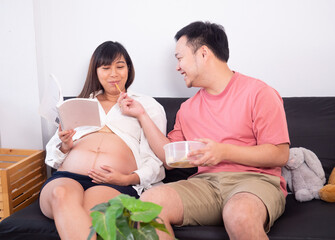 Healthy lifestyle of Young pregnant woman with her husband at home. A happy family concept.