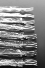 黒い背景の中のプラスチック製のスプーンやフォーク