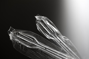 黒い背景の中のプラスチック製のスプーンやフォーク