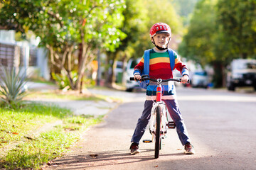 Boy going to school on bike. Kids ride bicycle.