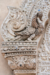Beautiful ancient bas-relief stucco decor of a mythological swan bird around door of hor trai library in Wat Phra Singh buddhist temple, famous landmark of Chiang Mai, Thailand
