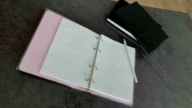 Hand writes with a pencil in a notebook