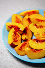 Fresh ripe nectarine peaches on ceramic plate. Delicious fruits for dessert
