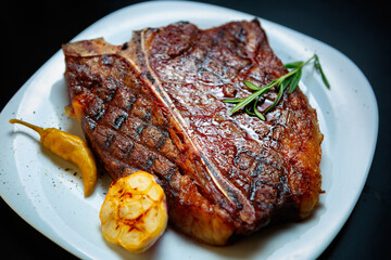 T-bone steak cooked on grill in American gourmet restaurant. Delicious beefsteak grilled with...