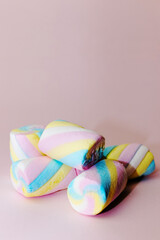 Colorful marshmallows candy on a pink background - vertical