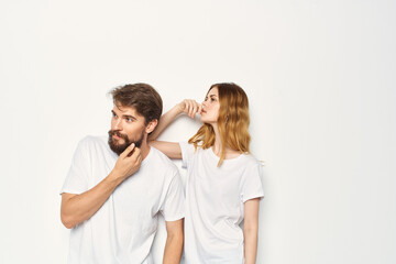 man and woman in white t-shirts are standing next to family light background