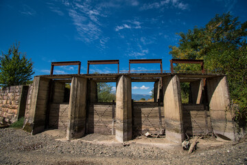 The riverbed without water, the drought takes its toll. The riverbedbed is paved with stones. Dam for regulation of the water.