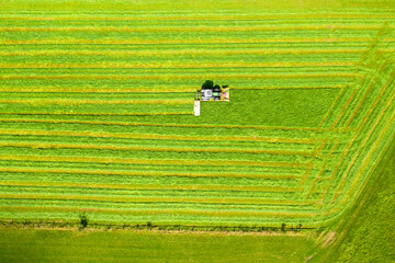 a tractor mows a field from above
