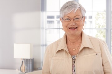 Closeup portrait of mature woman smiling happy, looking at camera.