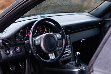 Fototapeta na wymiar Driver's seat of the car. Sport car interior. Steering wheel, shift lever and dashboard
