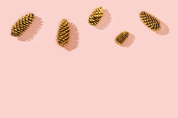 Natural  pine cone golden colored as New Year background with copy space. Bright Christmas holidays decor