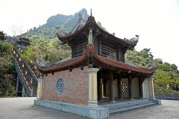 Pagoda on the territory of a Buddhist temple against the backdrop of mountains on a cloudy day
