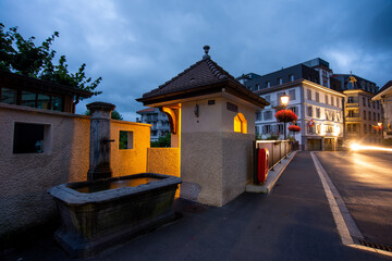 pont avec fontaine publique dans une ville touristique Suisse au lever du jour