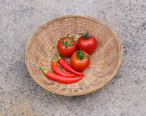 Fresh home grown tomatoes and peppers in a cane basket