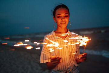Glowing sparkles in hands. Women with Christmas sparklers on nature and twillight sky background. Holidays, vacation, relax and lifestyle concept. - Powered by Adobe