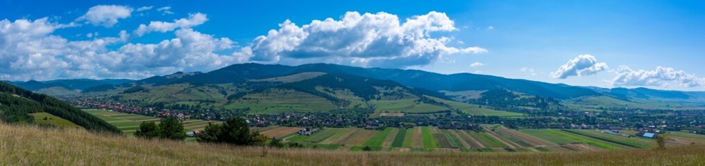 Fototapeta na wymiar Panoramic view of a hungarian village called Csikszentgyorgy in hungarian, Ciucsangeorgiu in romanian from the top of the mountain in Transylvania, Romania.