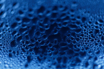 Drops on glass. Texture for designer background. Drops of water flow down the surface of the clear glass on a black background. Raindrops for overlaying on window. Concept of autumn weather.