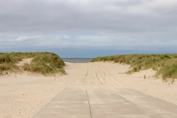 Papier Peint photo Lavable Mer du Nord, Pays-Bas Chemin de plage en béton et en sable sous des nuages nuageux gris blanc dans le ciel, Les dunes de sable ou la digue sur la côte néerlandaise de la mer du Nord avec de l& 39 herbe marram européenne (herbe de plage) Hollande du Nord, Pays-Bas.