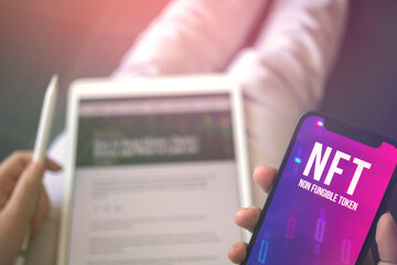 NFT logo on screen. Non fungible token, crypto art in real life concept. Virtual token and cyber technology background photo