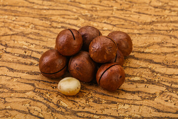 Brown macadamia nut heap over background