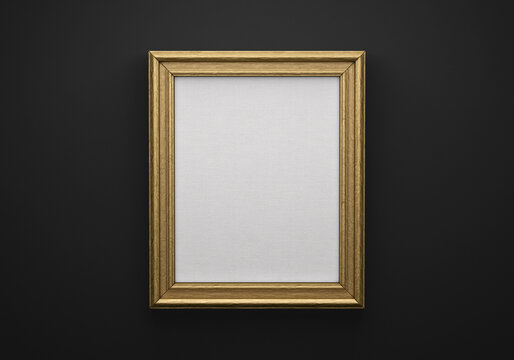 The bronze color picture vertical frame on black wall with textured blank canvas, 3D mockup