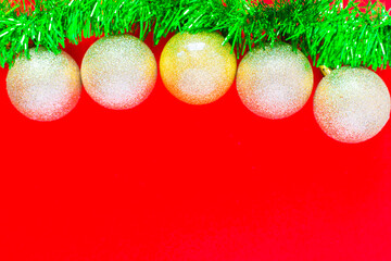 Christmas balls of silver color hang on a green fluffy garland tinsel of green color on top of the...