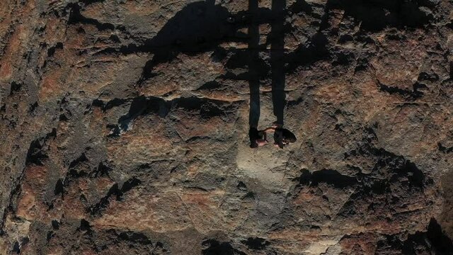 Two men  have kung fu practice. Aerial view to sportsmen people by the sea on the sunset. Golden light, blue sky and ocean. Men fight. Drone flies up. Bird's view