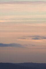 Vertical hazy sunset. Horizon under warm and faded pastel colours.