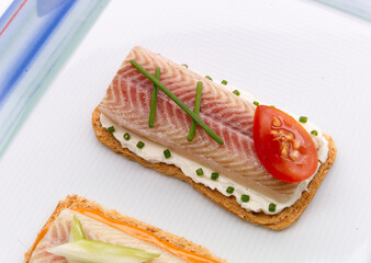Aperitivo, canapé de pescado ahumado con queso cremoso con tomate y cebollino. Appetizer, smoked...