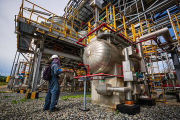 Male worker inspection at steel long pipes and pipe elbow in station oil factory during refinery...