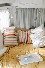 Bedroom interior, bed with colorful pillow, tray at cozy home.