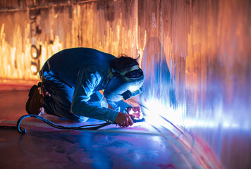 Welding  arc argon worker male repaired metal is welding sparks industrial construction tank...