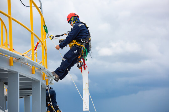 Male workers control rope down top roof tank rope access inspection of thickness shell plate storage tank gas