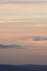 Fototapeta na wymiar Vertical hazy sunset. Horizon under warm and faded pastel colours.