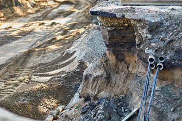 Laying underground storm sewers at a construction site. Installation of water main, sanitary sewer, storm drain systems in city. Deep foundation pit. Selective focus.