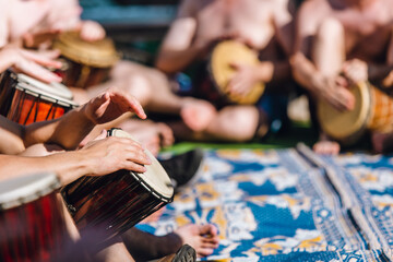 People having fun playing with their hands in a drum circle on djembe - obrazy, fototapety, plakaty