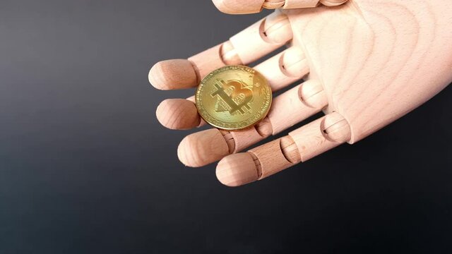 gold metal coin bitcoin on a wooden hand model, the concept of buying and paying with electronic money, the rise and fall of the bitcoin rate, trading