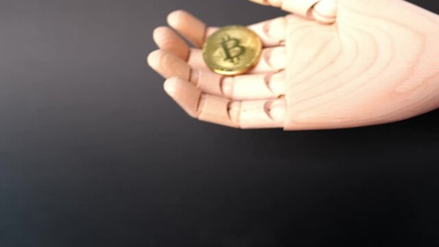 gold metal coin bitcoin on a wooden hand model, the concept of buying and paying with electronic money, the rise and fall of the bitcoin rate, trading