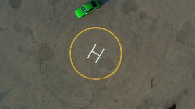 Ariel Overhead Shot Drift Sports Car In A Circle. Ariel Overhead Shot Drift Sports Car In A Circle. Helipad