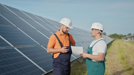 Technician of energy checking the solar cell panels at solar farm energy. Solar energy from Sun...