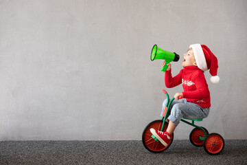 Happy child riding bike. Christmas holiday concept