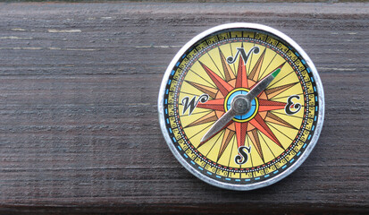 round compass on natural wooden background as symbol of tourism with compass, travel with compass and outdoor activities with compass