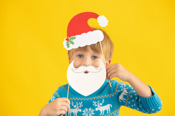 Fototapeta na wymiar Happy child holding Santa Claus hat and beard