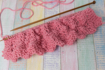 wooden knitting needles with pink wool yarn 