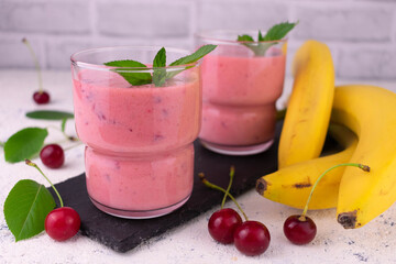 Two glasses of banana and cherry smoothie.
Close-up.