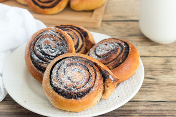 Sweet, homemade cocoa rolls served on a kitchen table with a glass of milk