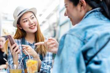 Traveler Asian woman friend travel in Bangkok, Thailand, sweet couple taking photo . Lifestyle couple travel in city concept.Young fun happy Asian tourist backpacker travel eating street food.