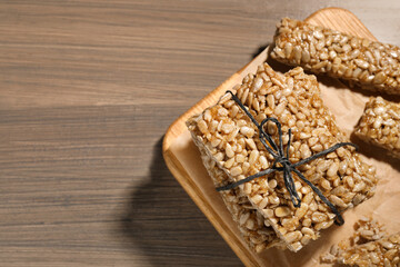 Delicious sweet kozinaki bars on wooden table, top view. Space for text